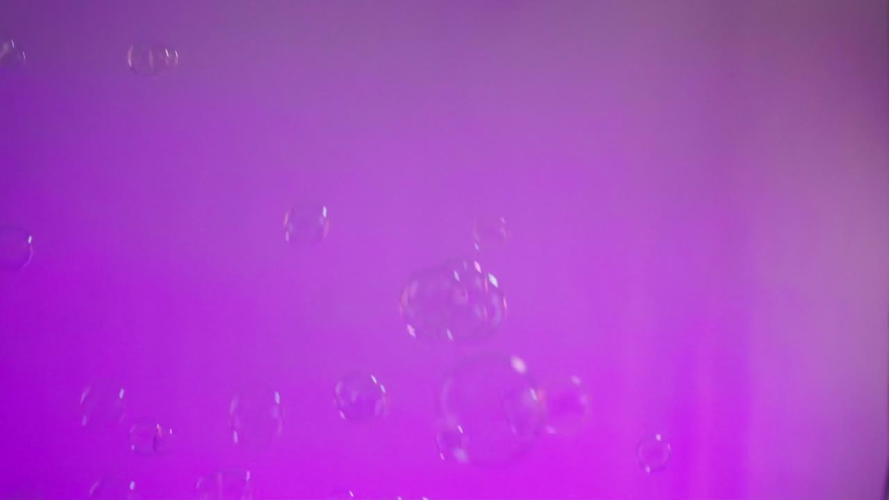 Bubbles surfacing against a purple field