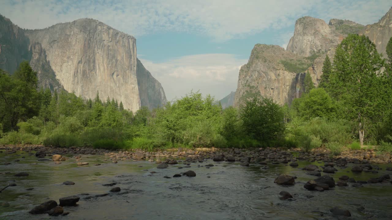 pan up revela el capitán y bridalveil cae detrás del río merced en el parque nacional de yosemite, california, ee.uu.