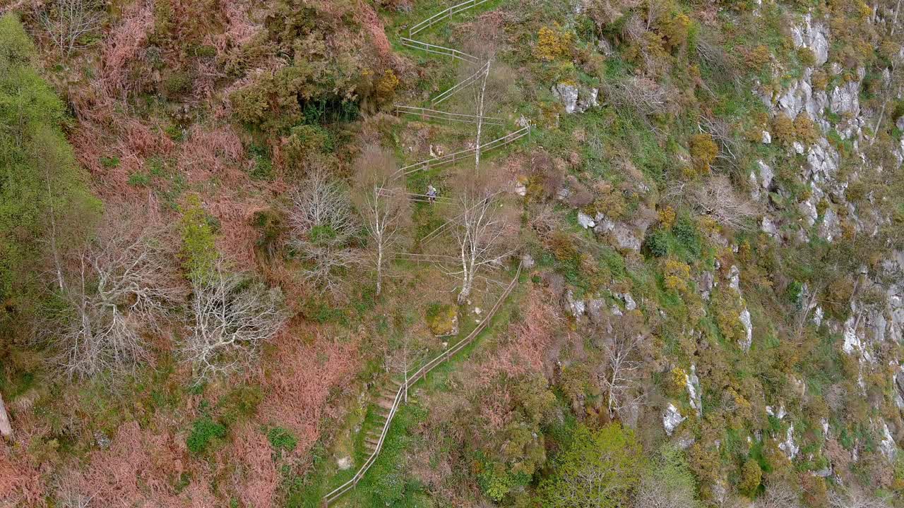 그 여자는 소르 강 계곡에 초목이 있는 절벽의 보호된 길을 따라 올라간다