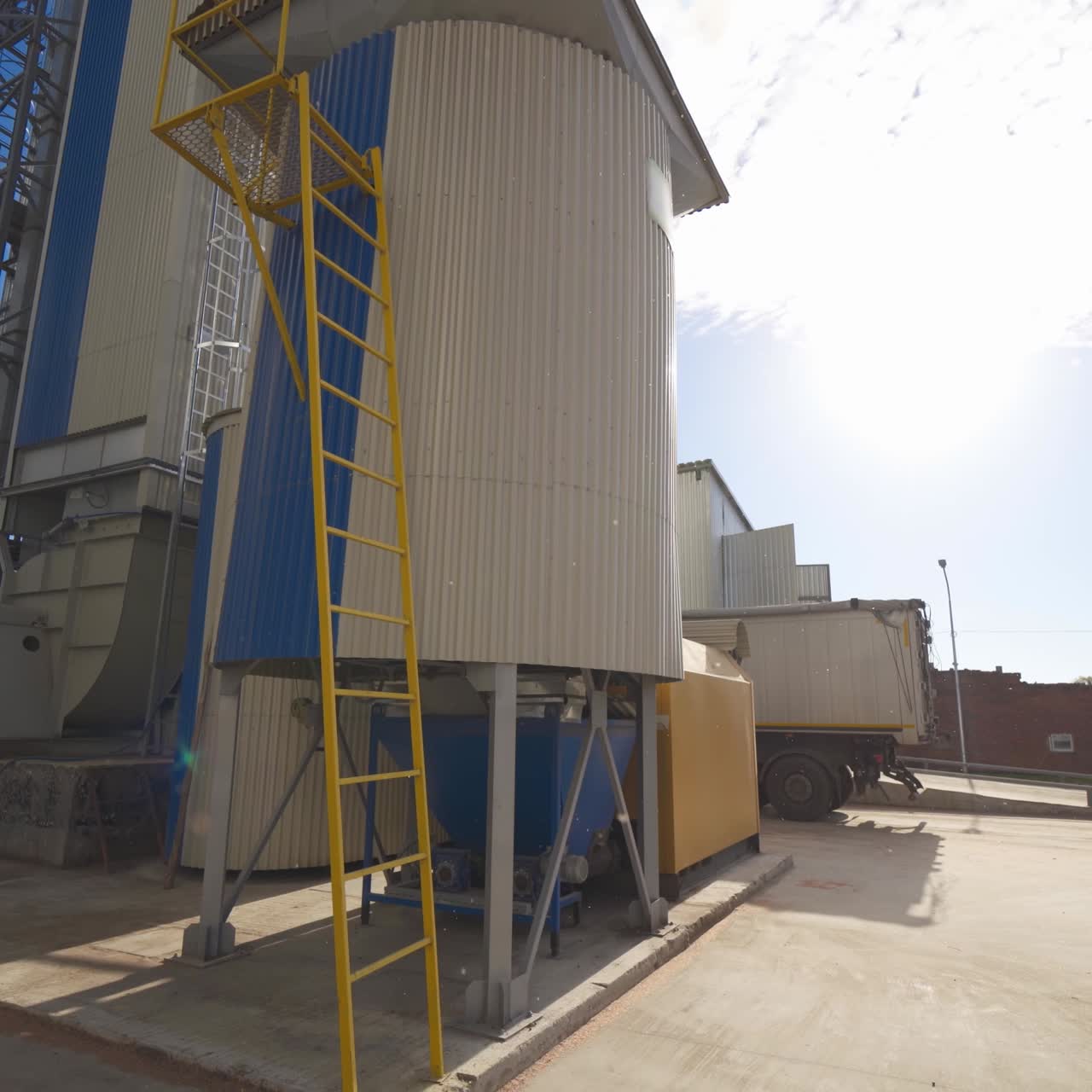 Metal equipment on the large agricultural factory. Exterior of agricultural complex with huge grain elevators. Modern processing plant