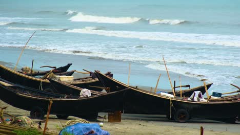 fishing trawler boats sit idle on kuakata beach as black crow lands