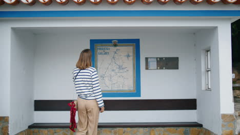 chica esperando parada de autobús sola vertical. viajero de la ciudad comprobar mapa de la carretera en vacaciones