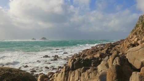 Olas-Salpicando-En-La-Costa-Rocosa-De-Porth-Nanven,-Cornualles,-Inglaterra,-Plano-General