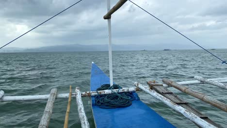 sailing a bangka boat through grey cloudy seas