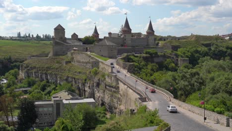 ucrania, la vista aérea del castillo de kamianets podilskyi hacia atrás en un día nublado con cielos azules.