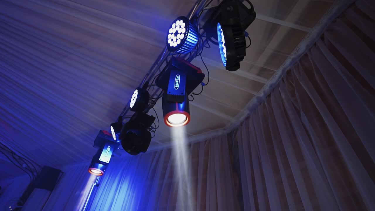 Musical spotlights. Colorful lights from projectors shimmering in the dancing hall. Modern equipment shining with different colors.