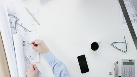 top view architect designing connected home using smartphone touchscreen hands working at desk from above - red epic dragon