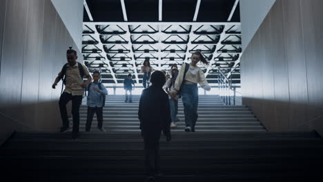 depressed little boy going upstairs near lively pupils crowd. children running.