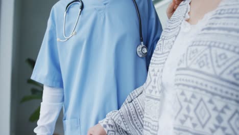 Smiling-asian-female-doctor-helping-happy-female-patient-walk-with-walking-frame-at-hospital