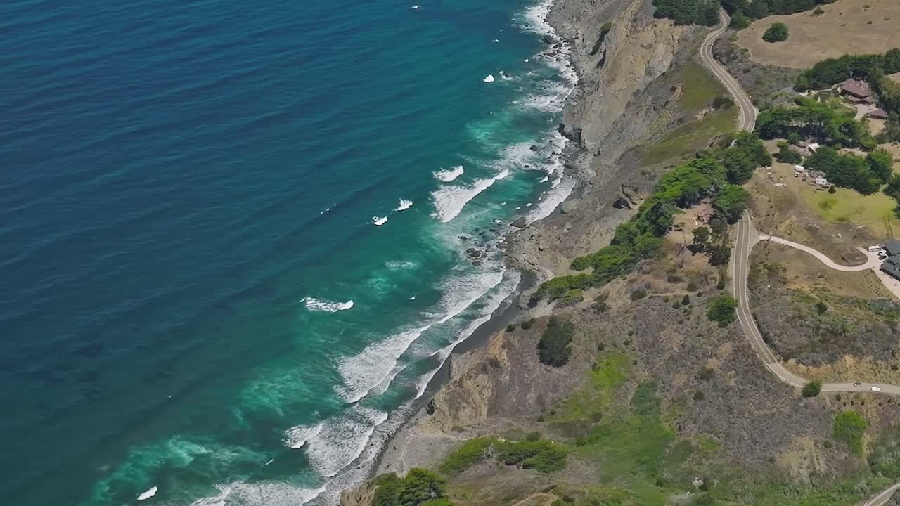 Veduta della costa californiana con onde e colline verdi negli USA.