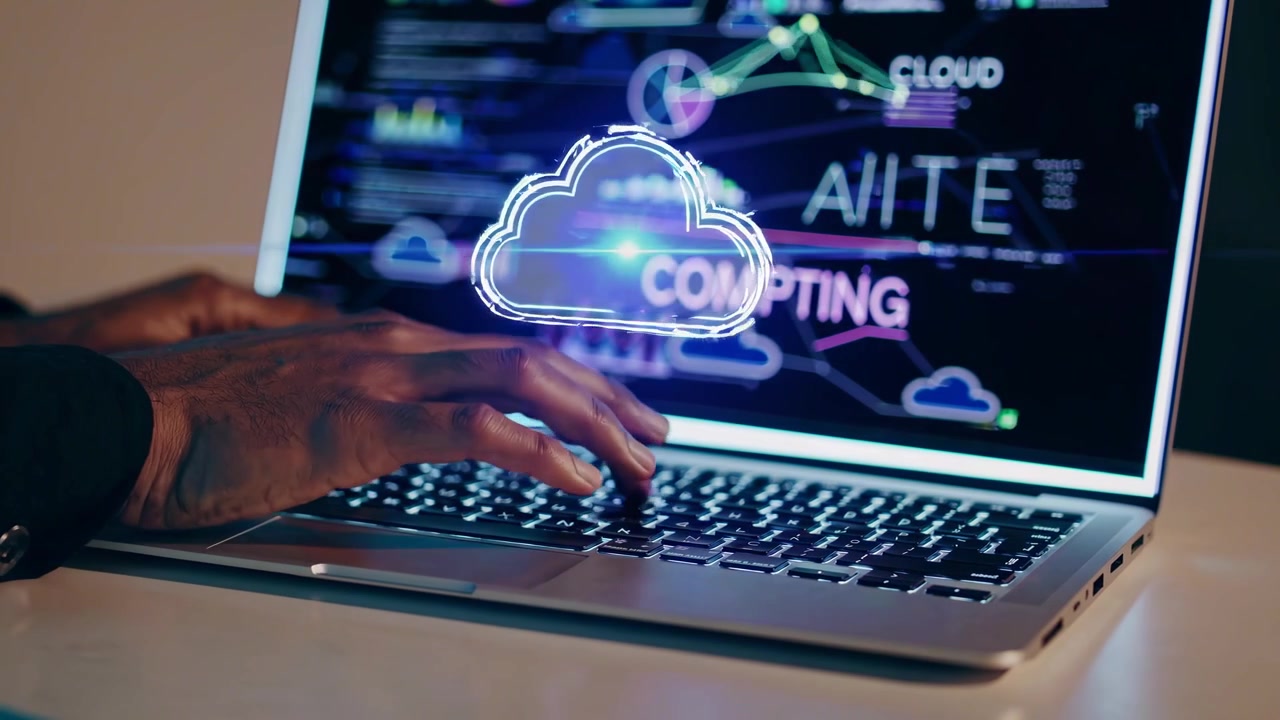 Gros plan de mains tapant sur un ordinateur portable avec des graphiques de cloud computing