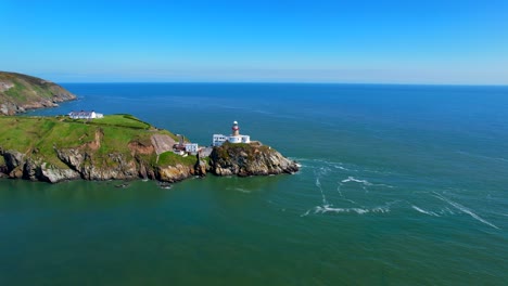 aerial view of a lighthouse revealing rocky coast and peninsula