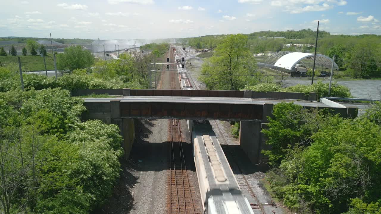 Aerial drone video of a bridge going over a railroad.