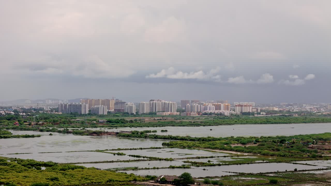 Aerial shot of flooded farmland with urban cityscape at a distance. Infrastructure.