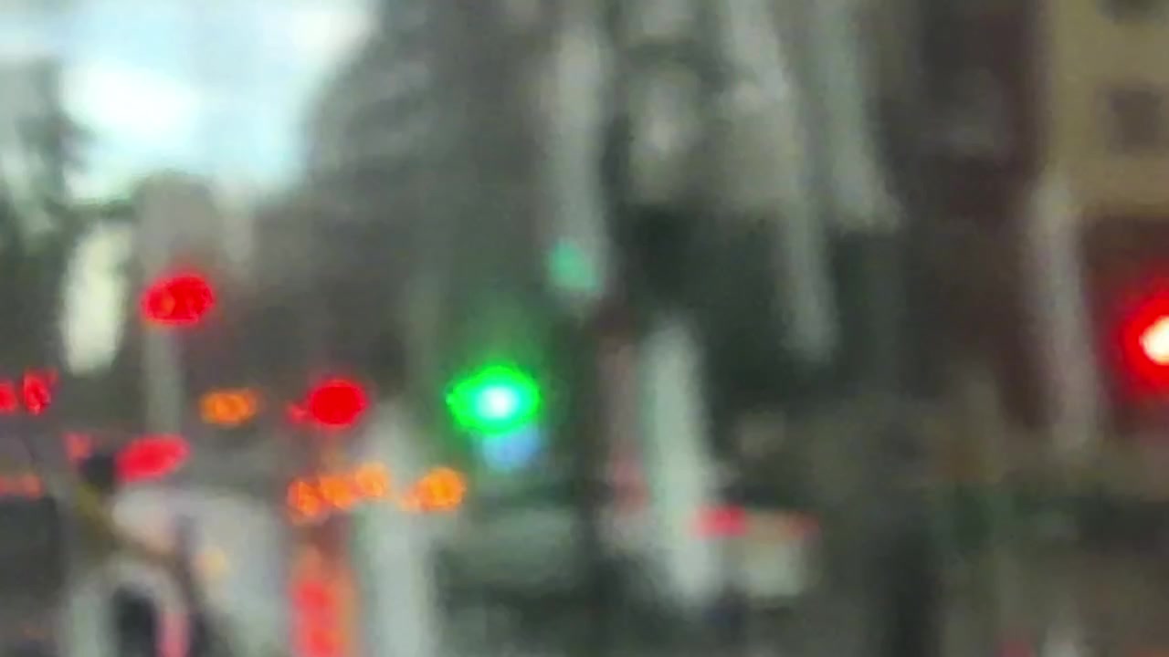 Strada cittadina sfocata con bokeh colorato delle luci del traffico.
