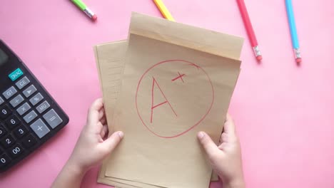 schüler mit einem a+-papier