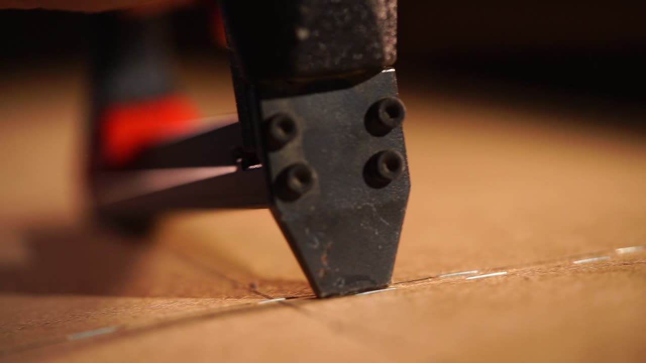 primer plano de una pistola de clavos para enganchar madera