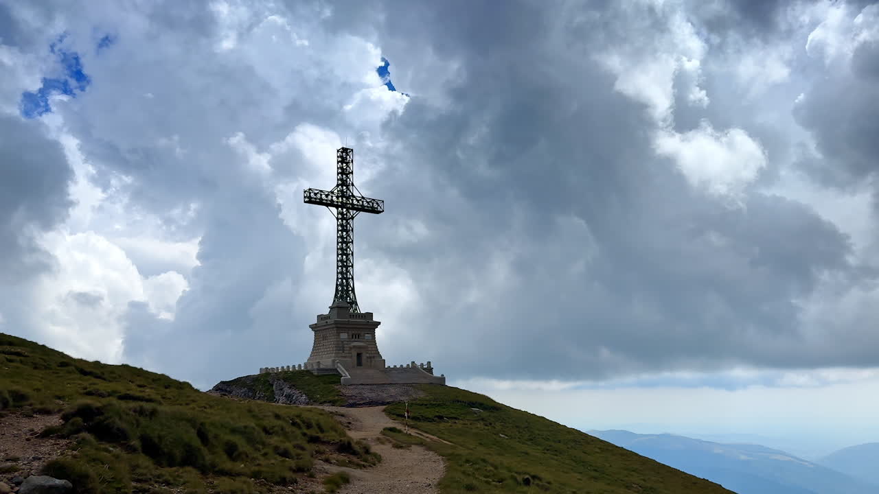 Heroes' Cross on the Caraiman Peak against cloudy sky. Landmark of Bucegi mountains, Romania