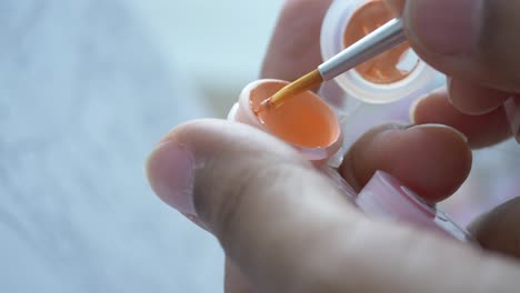 aplicando pintura naranja con un pincel