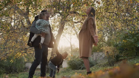 family with two children have fun in autumn park