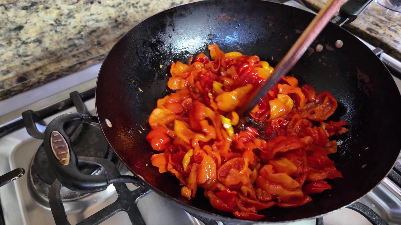 Colorful peppers frying in a pan, vibrant cooking scene in kitchen