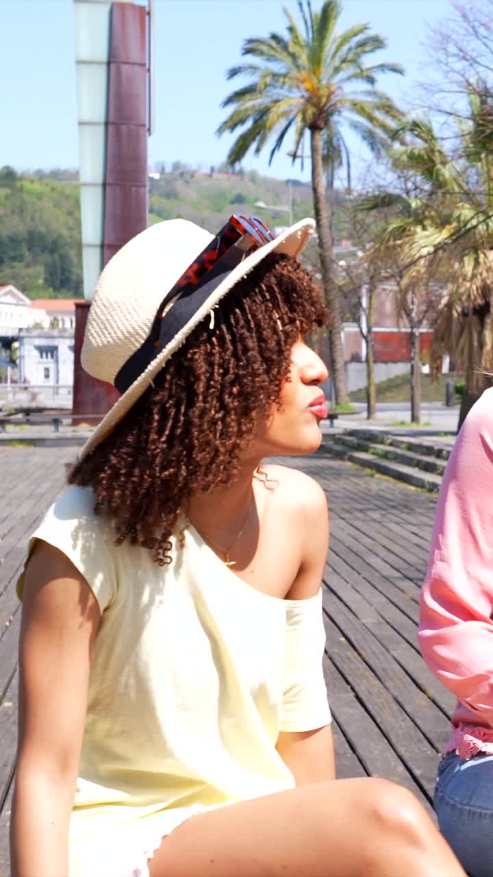 Two Young Women Enjoying a Conversation Outdoors