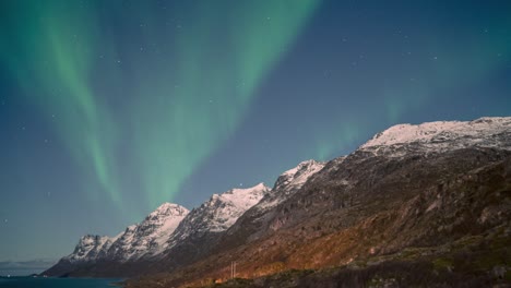 Una-Exhibición-De-Aurora-Boreal-Iluminada-Por-La-Luna-Sobre-Los-Fiordos-árticos-Y-Las-Montañas-Del-Norte-De-Noruega