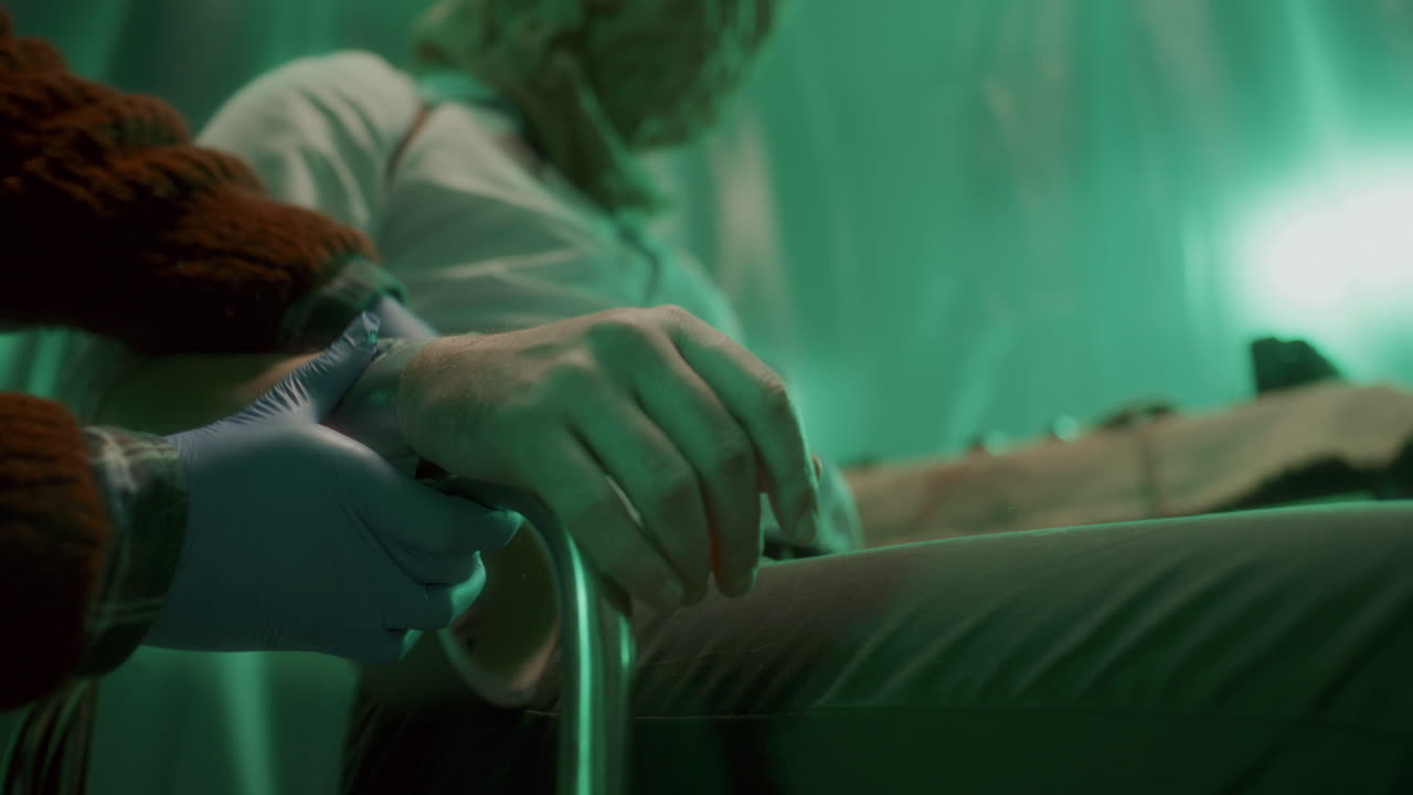 primer plano del criminal usando cinta adhesiva para atar las manos de la víctima a la silla