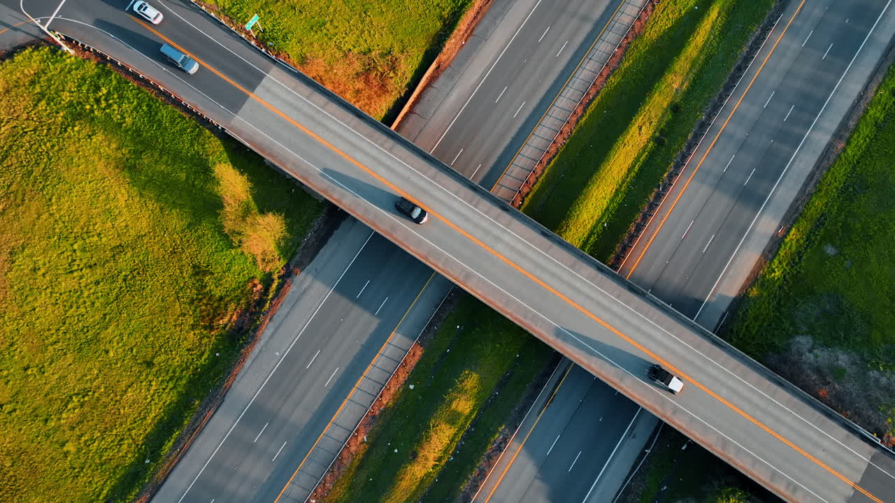 Freeway above two highways in the countryside. Top view on the roads with cars moving by on sunny day.