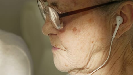 senior woman with headphones video calling at home