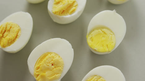 Video-of-close-up-of-halves-of-hard-boiled-eggs-on-grey-background