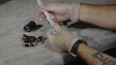 artista del tatuaje preparando la máquina de tatuaje