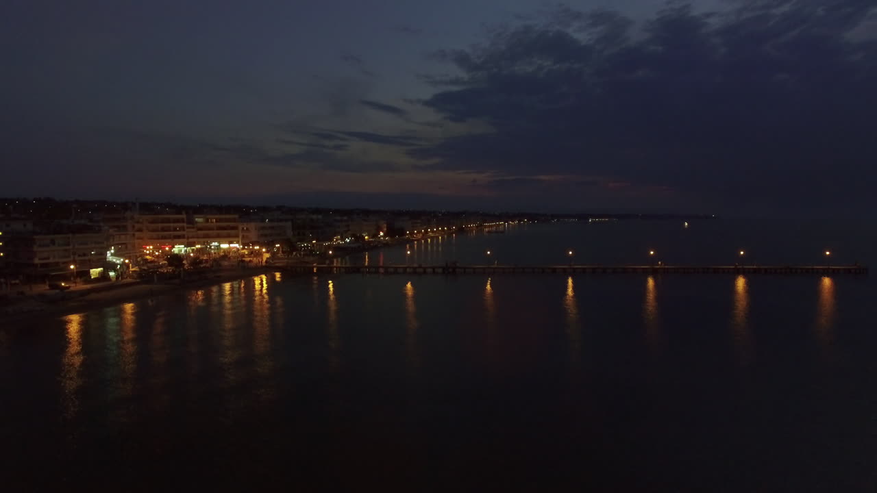 vista aérea del complejo y el mar con el muelle por la noche