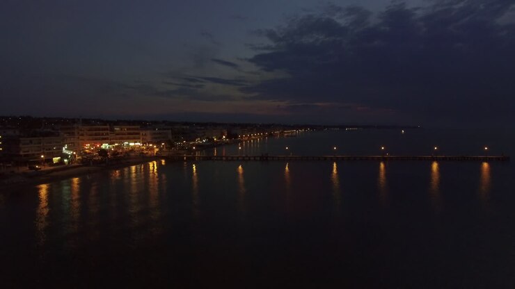 Vue aérienne d'un complexe hôtelier et de la mer avec une jetée la nuit