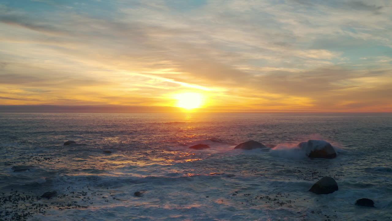바위 가 있는 해안선 을 가로질러 해가 지는 것