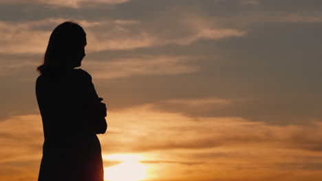 Silhouette-Einer-Jungen-Frau-Allein-Bei-Sonnenuntergang-Mit-Blick-In-Die-Ferne