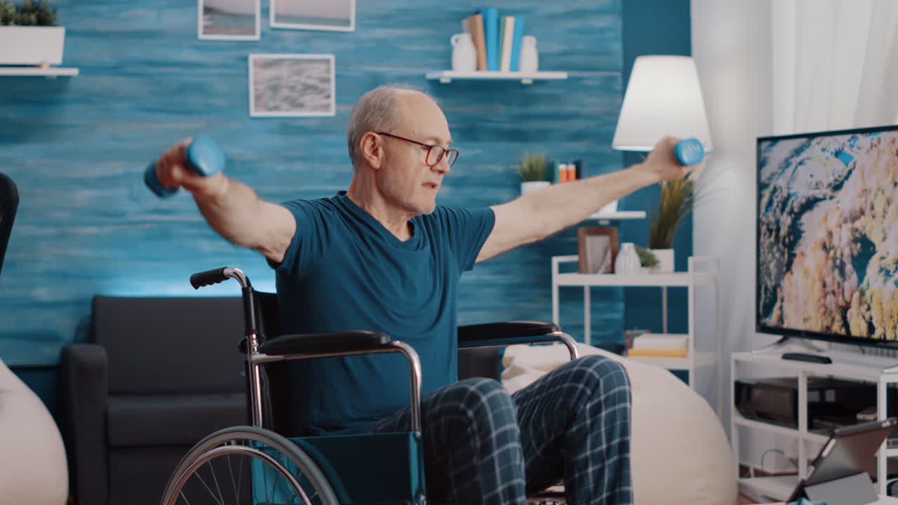 Retired man sitting in wheelchair and lifting dumbbells
