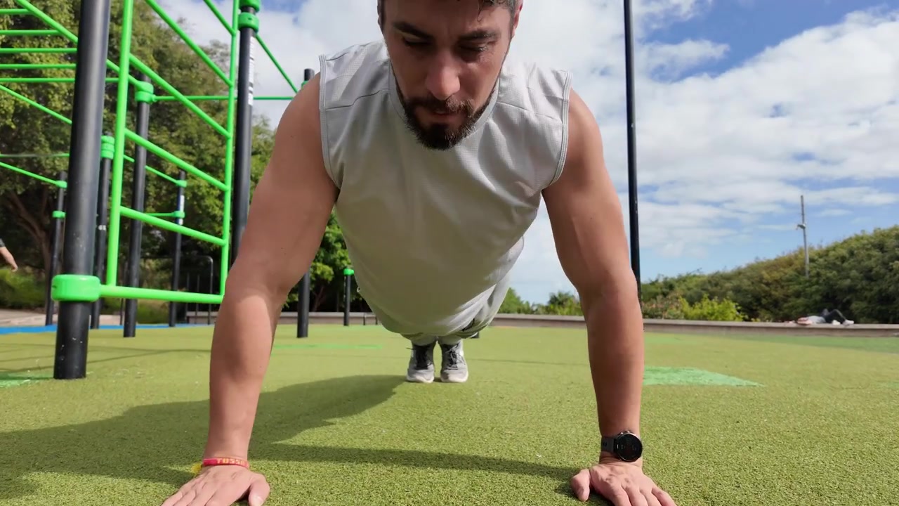 Giovane uomo che fa flessioni in un parco all'aperto.