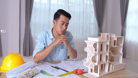 young architect looking house model and thinking about new architectural ideas