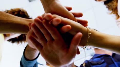 team of smiling graphic designers forming hand stack