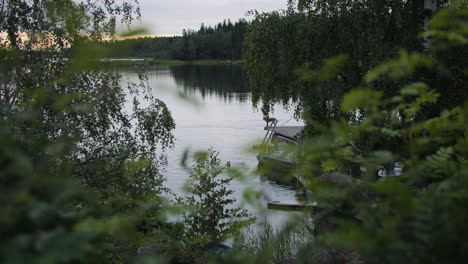 Man-in-late-night-swim-with-his-dog-in-Swedish-lake