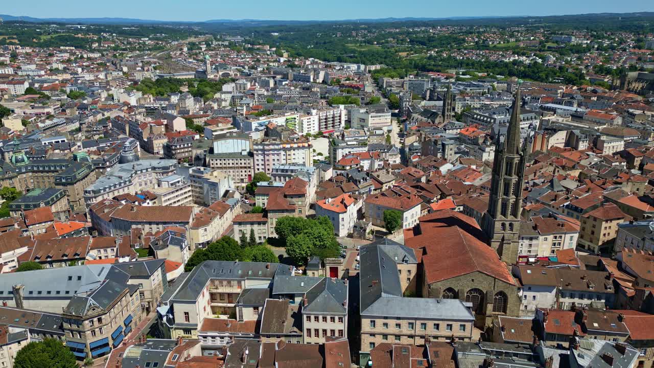 Et drone-tilbagetrækningsbillede afslører Saint-Michel-des-Lions Basilica i Limoges med omkringliggende hustage, gader og det urbane landskab, der strækker sig ud i det fjerne