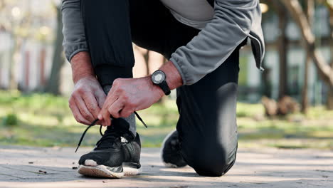 hombre atando sus zapatillas de correr antes de correr en el parque