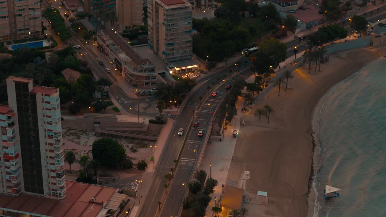 Seaside spanish city shot on night from above with buildings streets cars and a beach