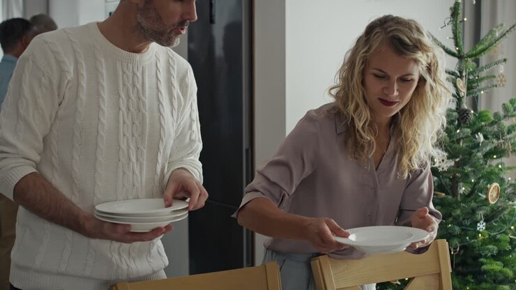 Happy caucasian family preparing table for Christmas Eve.