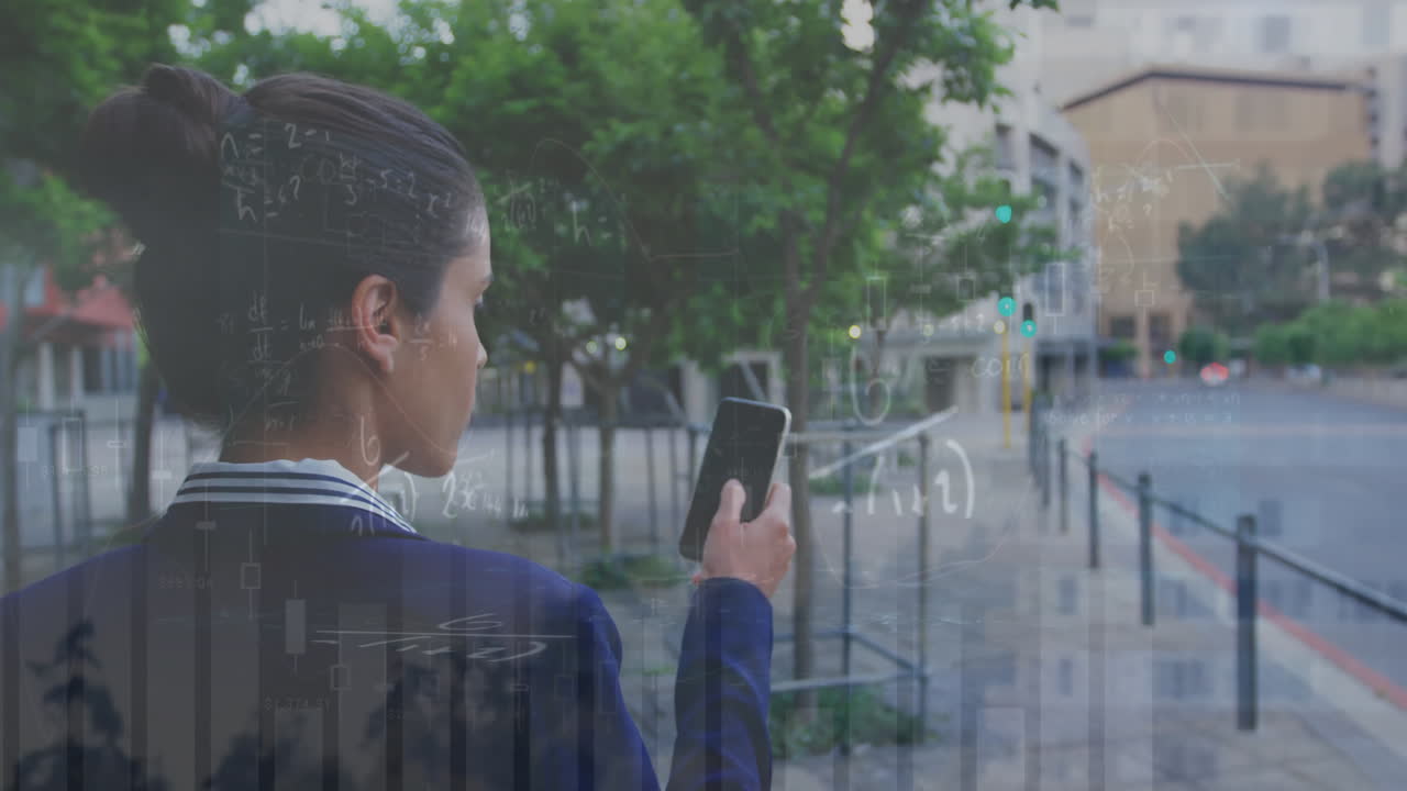 Animation of multiple graphs over rear view of biracial woman walking and using smartphone