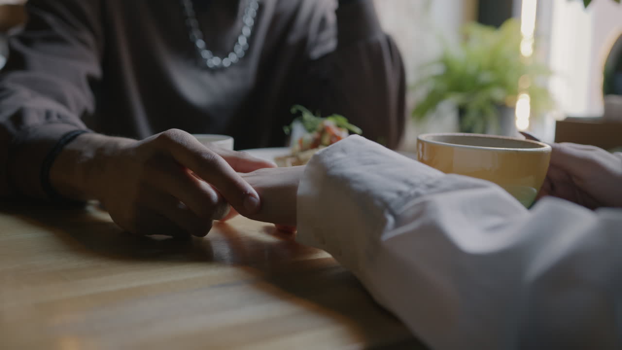 Couple holding hands at a cafe