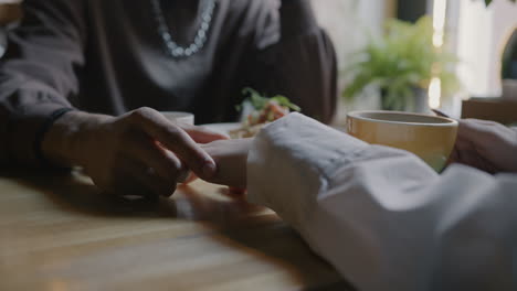 couple holding hands at a cafe
