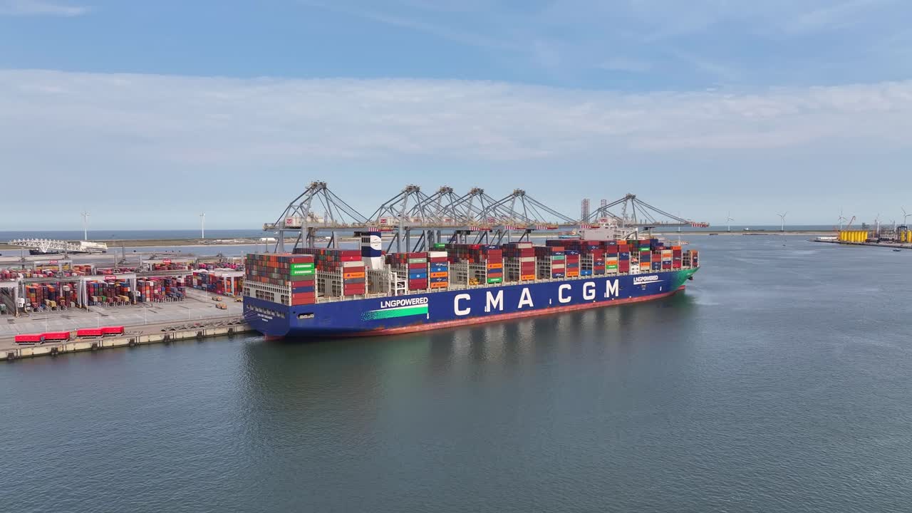 Large container ship docked at a busy port, cranes unloading colorful cargo in daylight