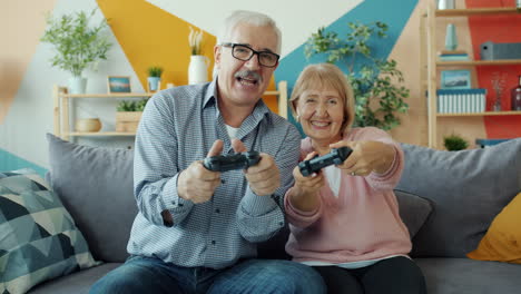 una pareja de mayores feliz jugando videojuegos.